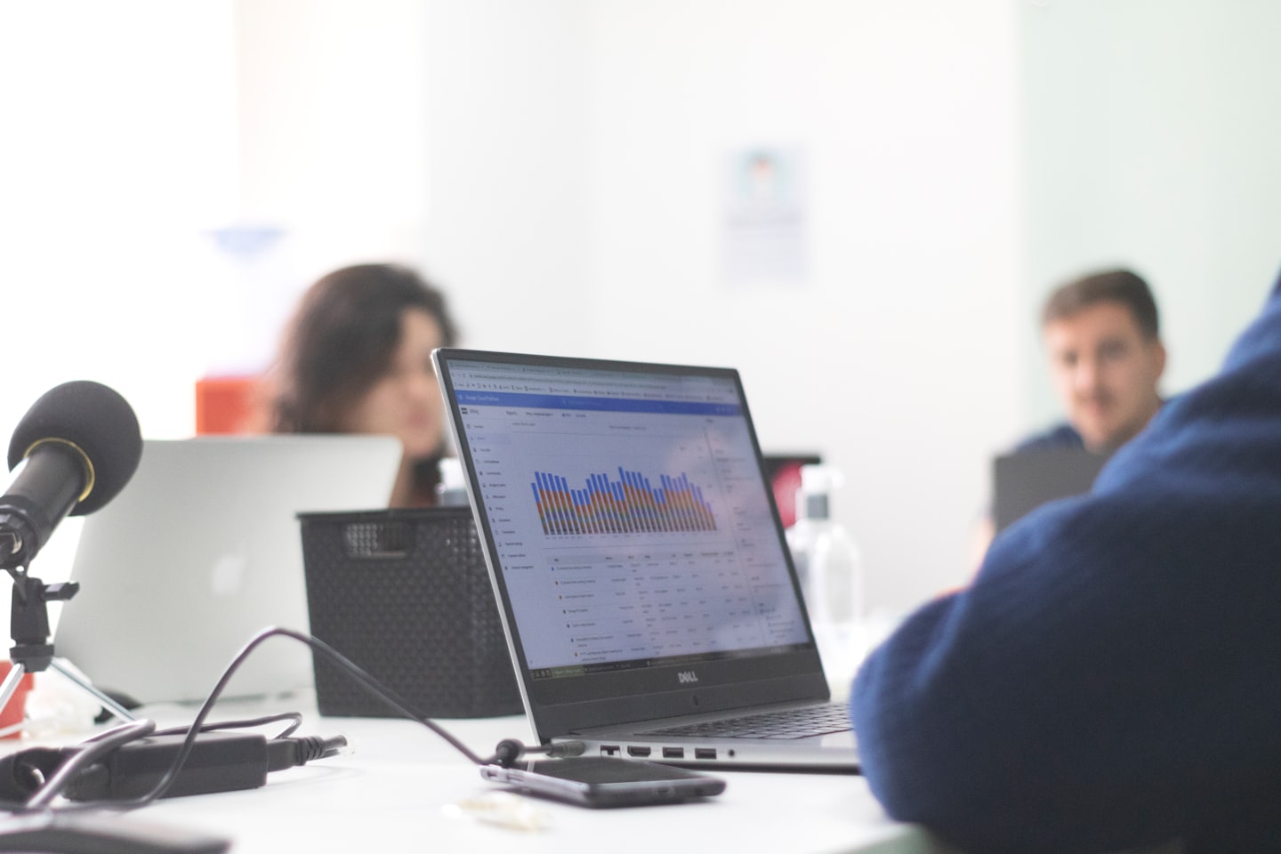 Persona de negocios trabaja en portátil con gráficos en un escritorio.